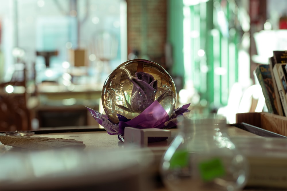 a vase with a flower inside of it sitting on a table