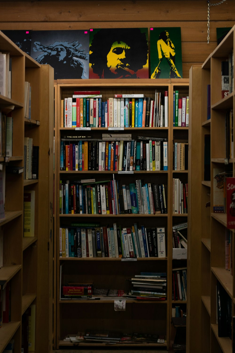 a bookshelf filled with lots of books in a room