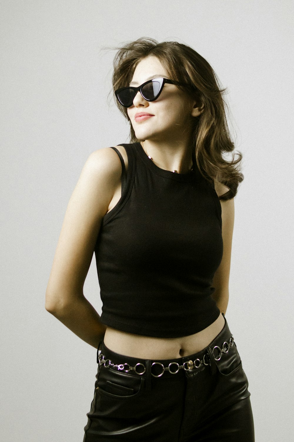 a woman wearing a black top and sunglasses