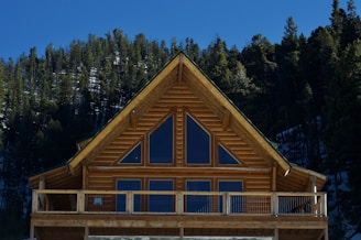 a wooden cabin with a balcony and a balcony railing