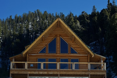 a wooden cabin with a balcony and a balcony railing