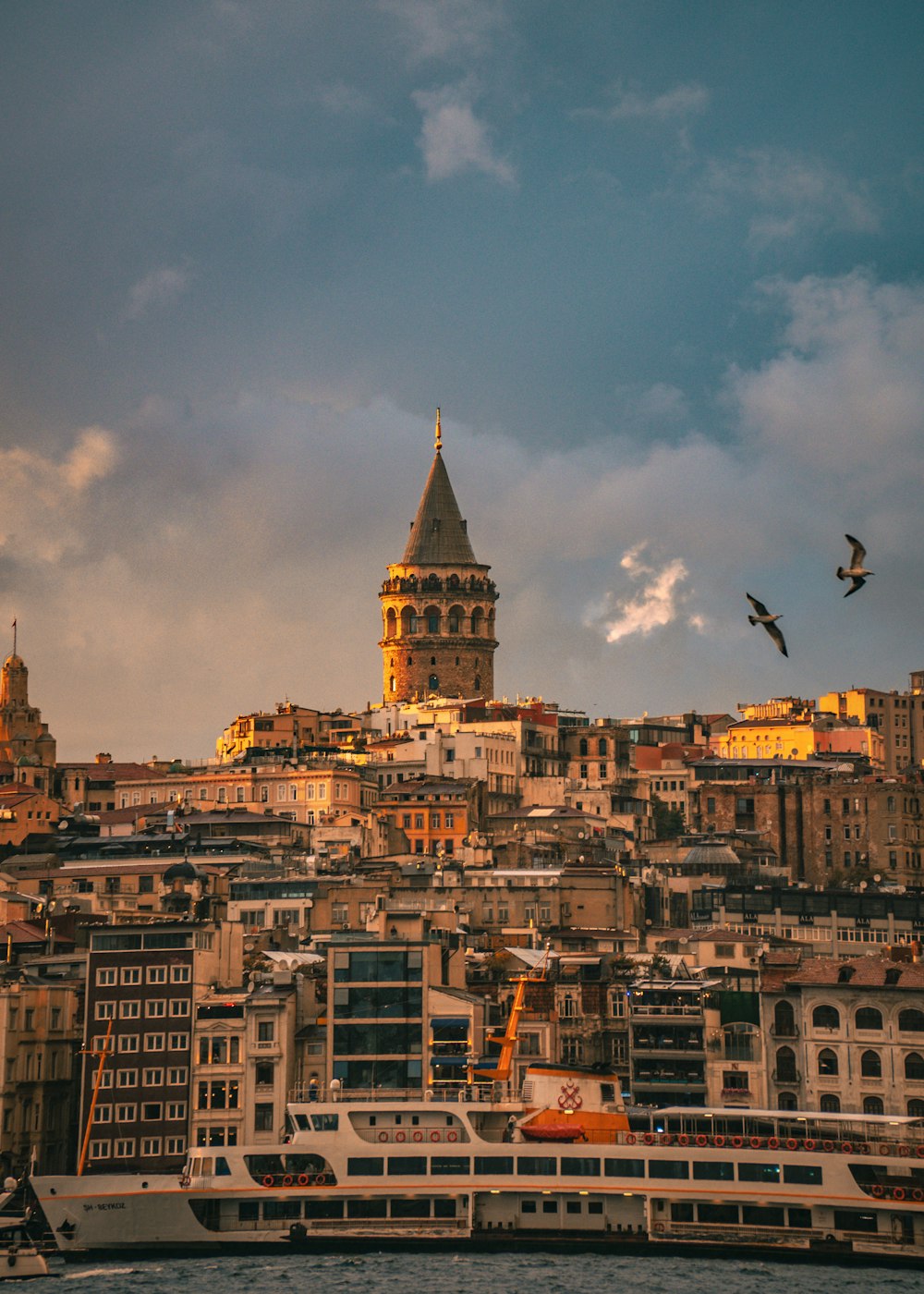 a city with a very tall clock tower next to a body of water