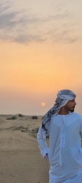 A vibrant photo of a traveler enjoying a desert sunset in Saudi Arabia.