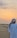 Traveler smiling against a dramatic desert sunset backdrop with dunes in Dubai