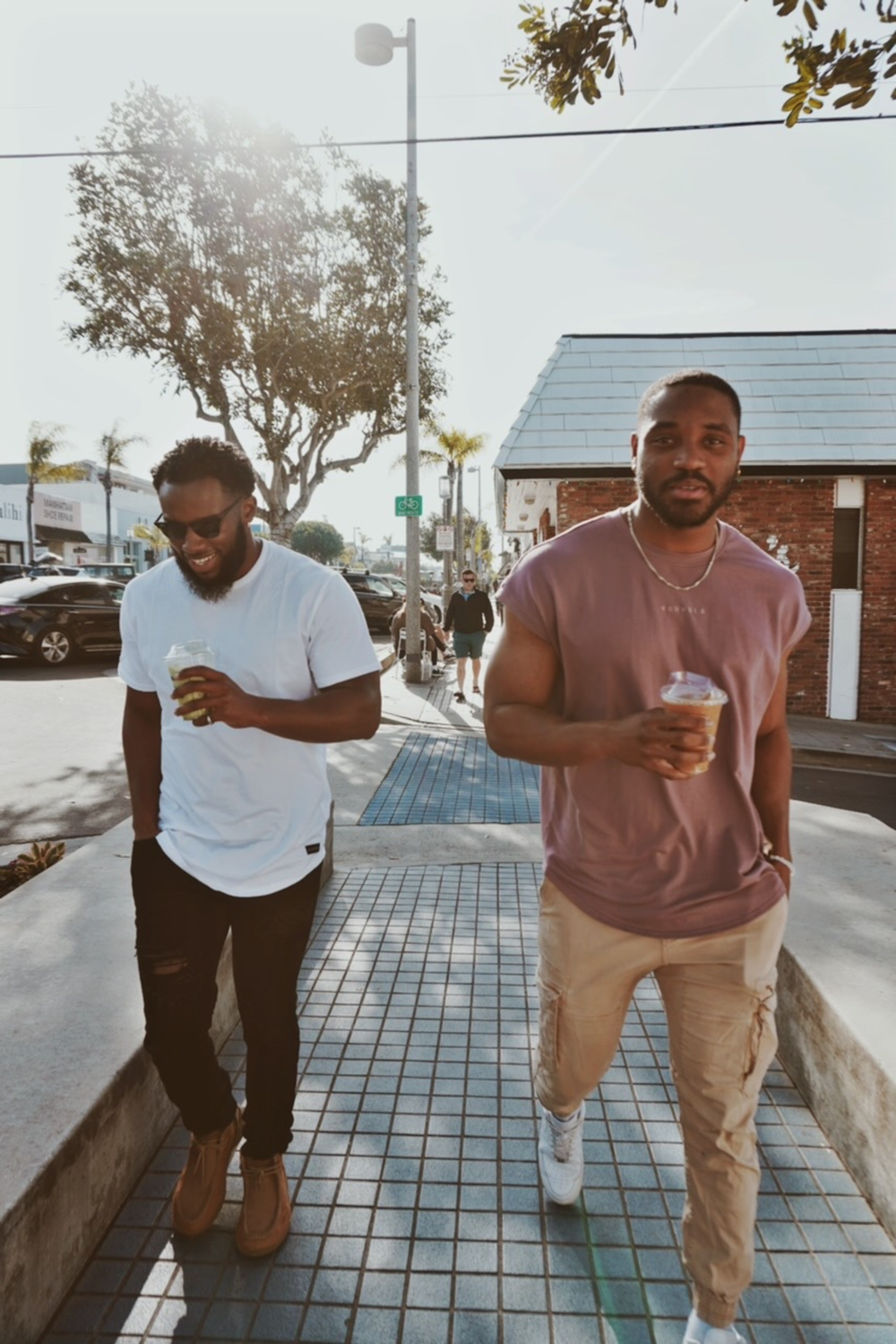 two men walking down a sidewalk next to each other