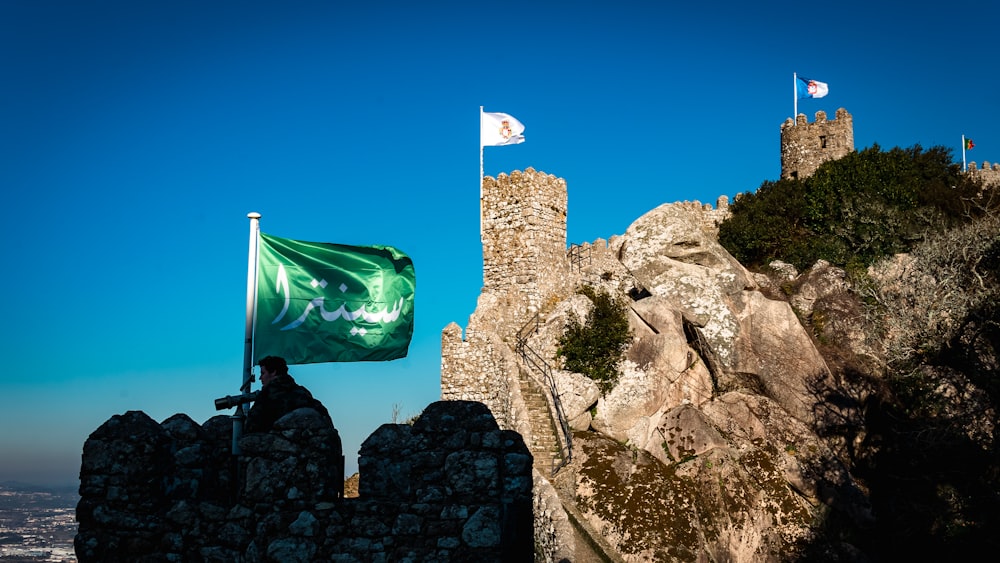 a flag flying on top of a stone castle