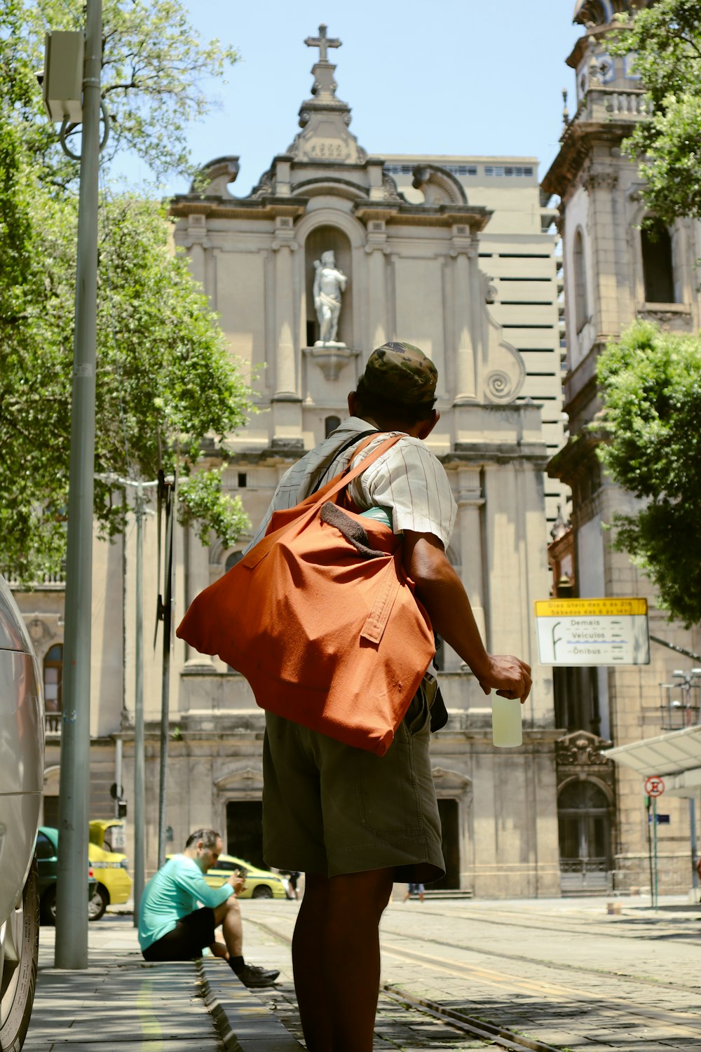 a man walking down a street with a bag on his back