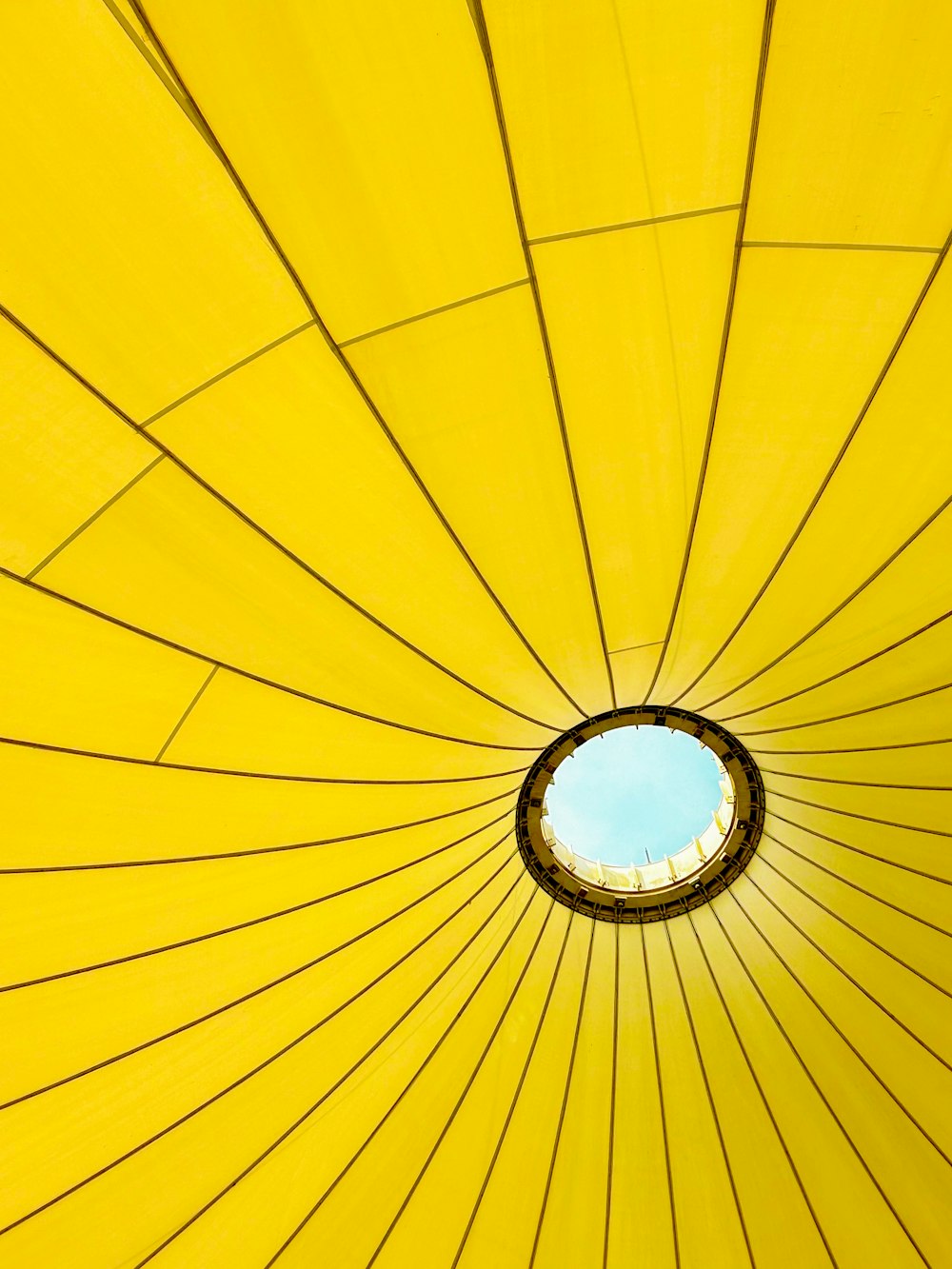 a yellow umbrella with a blue sky in the background