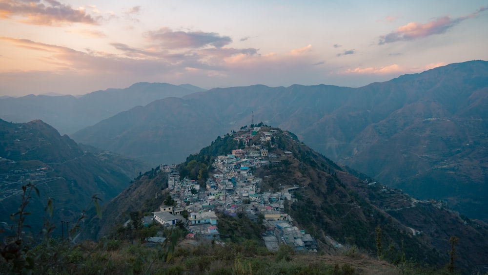 Un piccolo villaggio su una collina con le montagne sullo sfondo