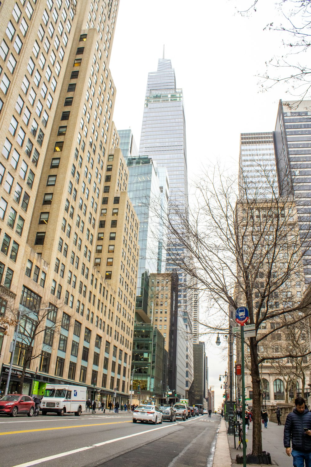 a city street lined with tall buildings and parked cars