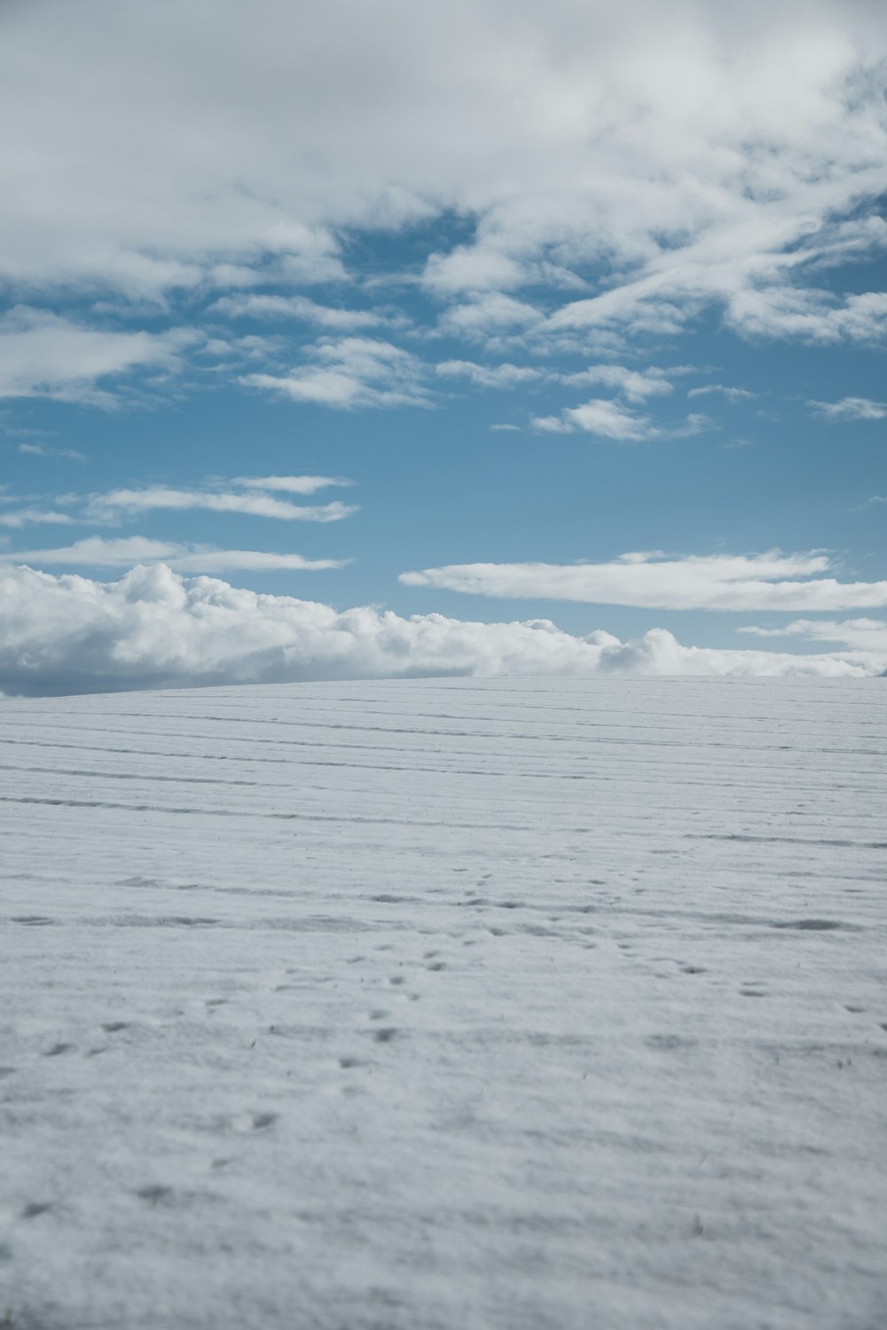 a vast expanse of white snow under a blue sky