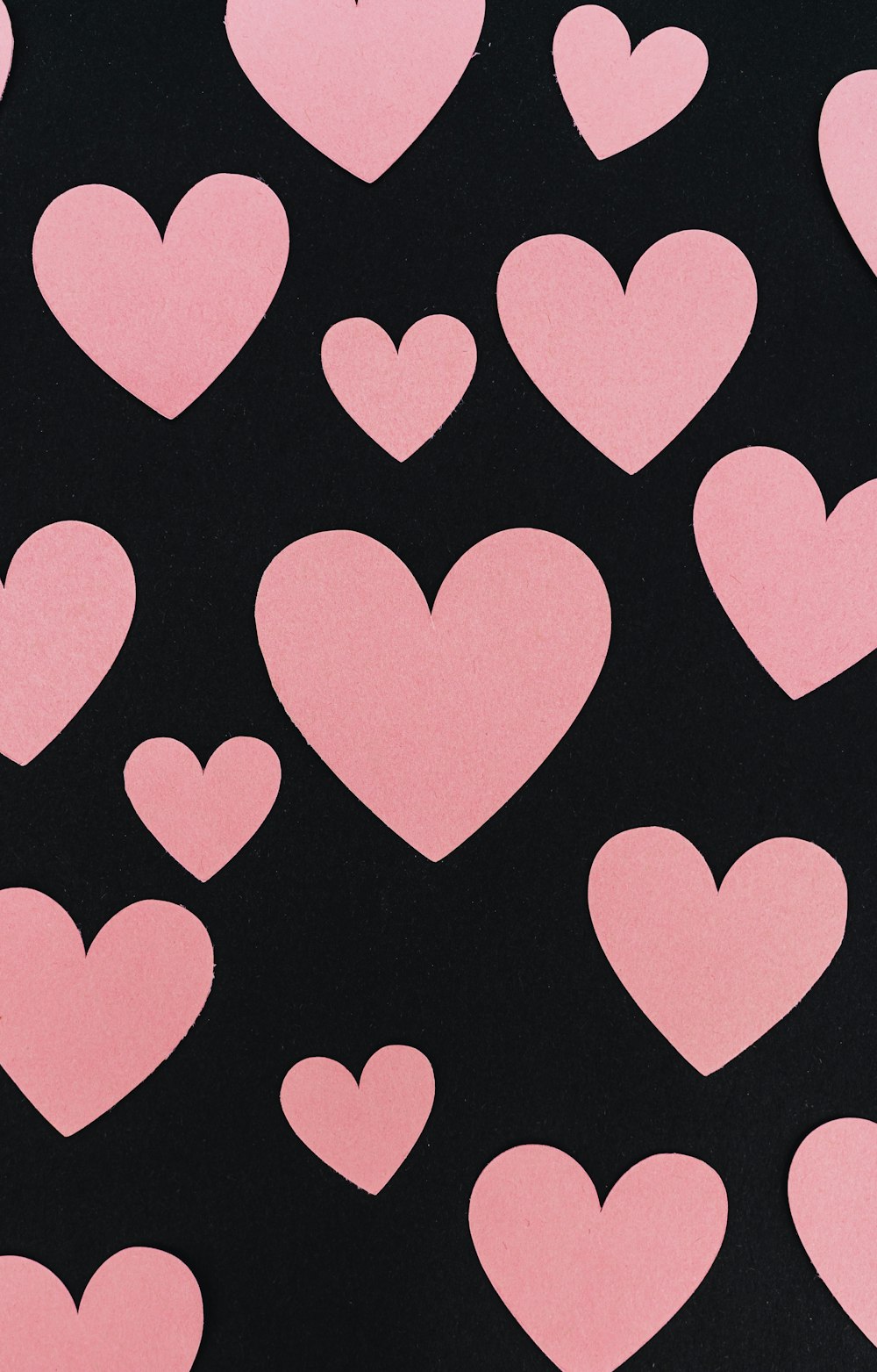 a bunch of pink hearts on a black background