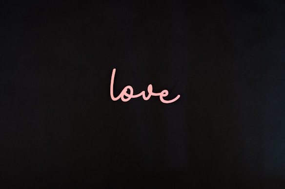 A black background with the word 'love' written in cursive using pink color at the center.