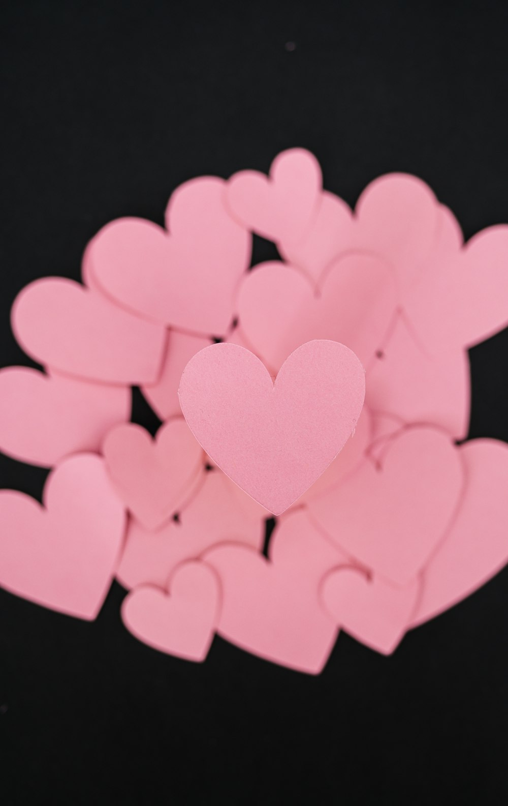 a bunch of pink hearts on a black background