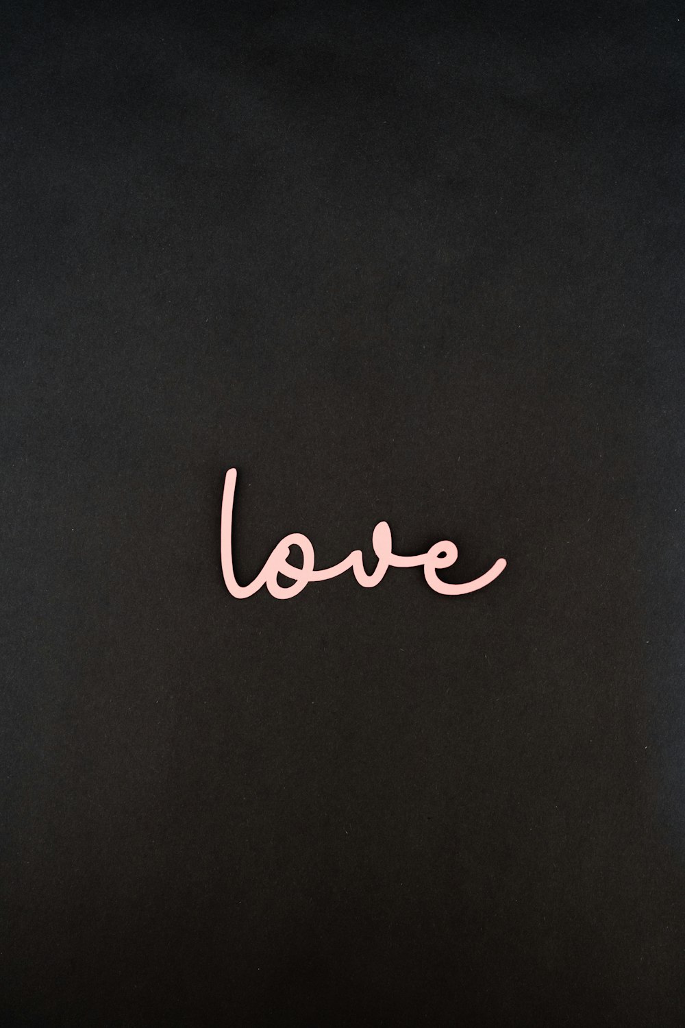 the word love written in pink on a black background