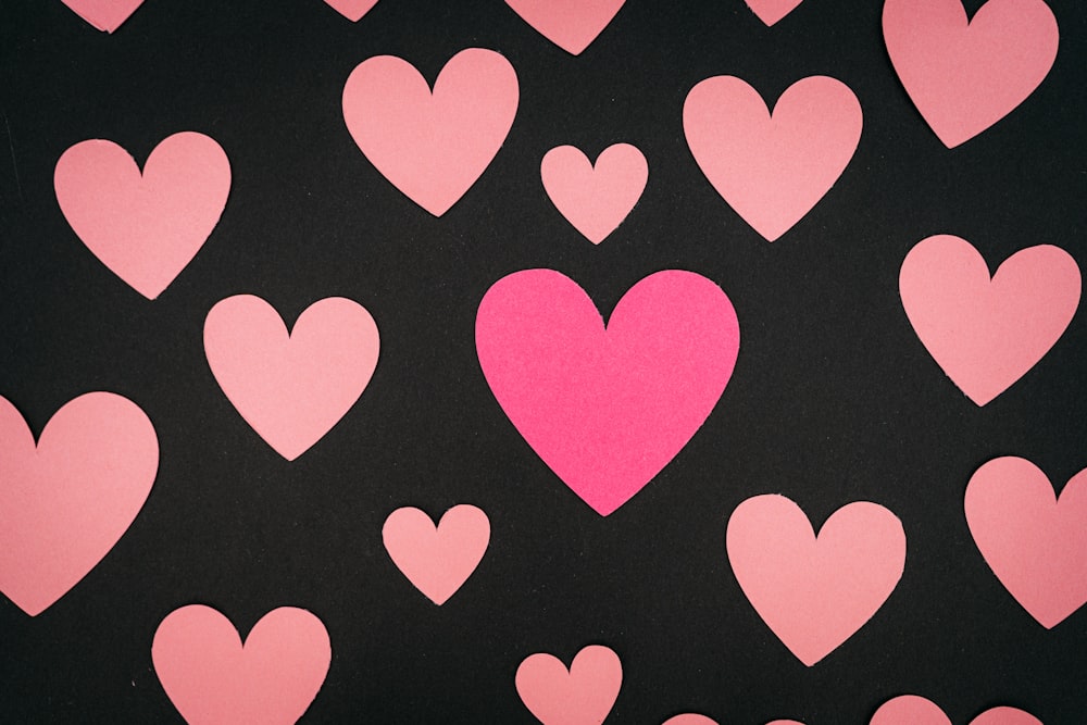 um grupo de corações cor-de-rosa em um fundo preto