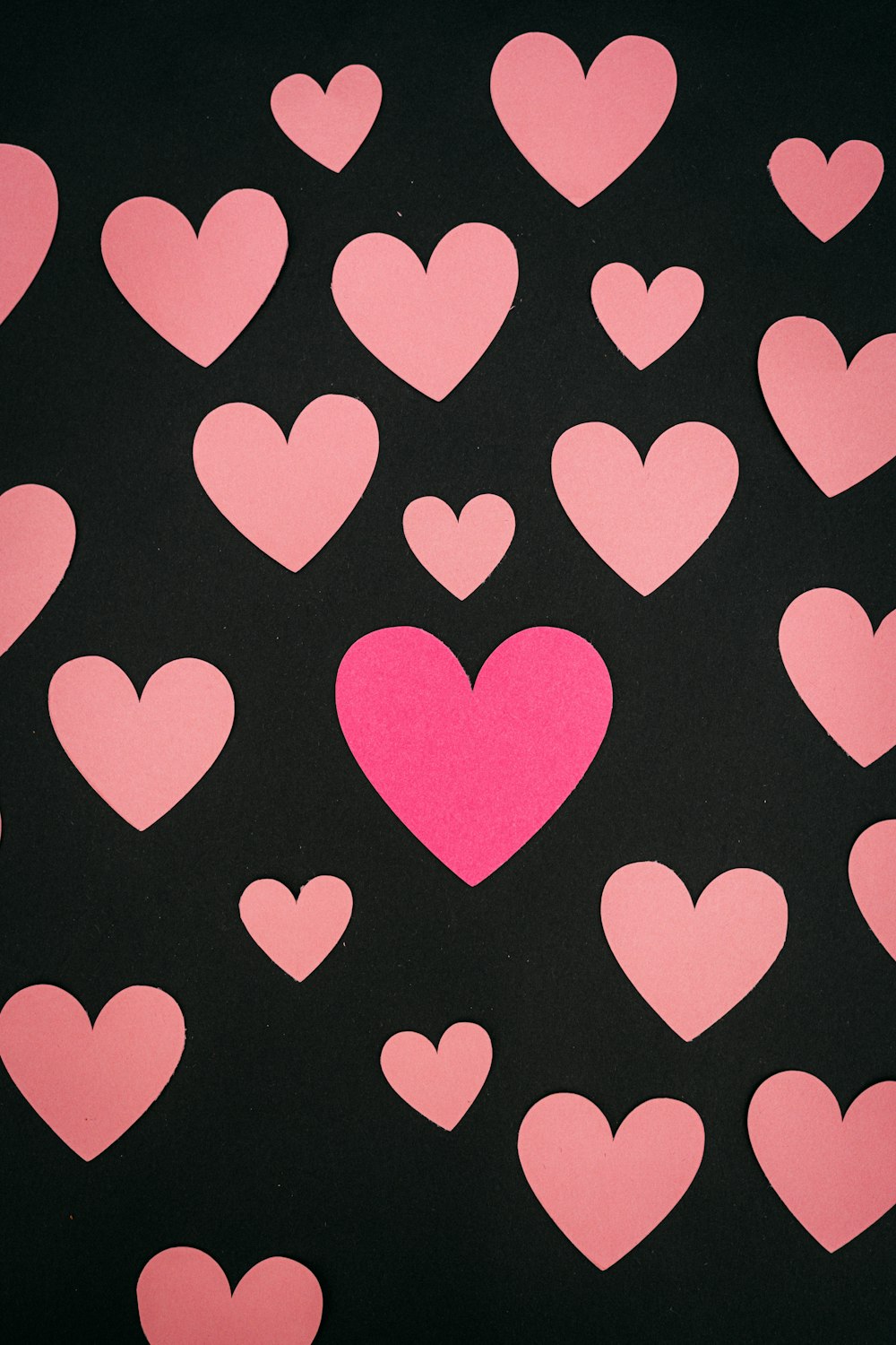 a bunch of pink hearts on a black background