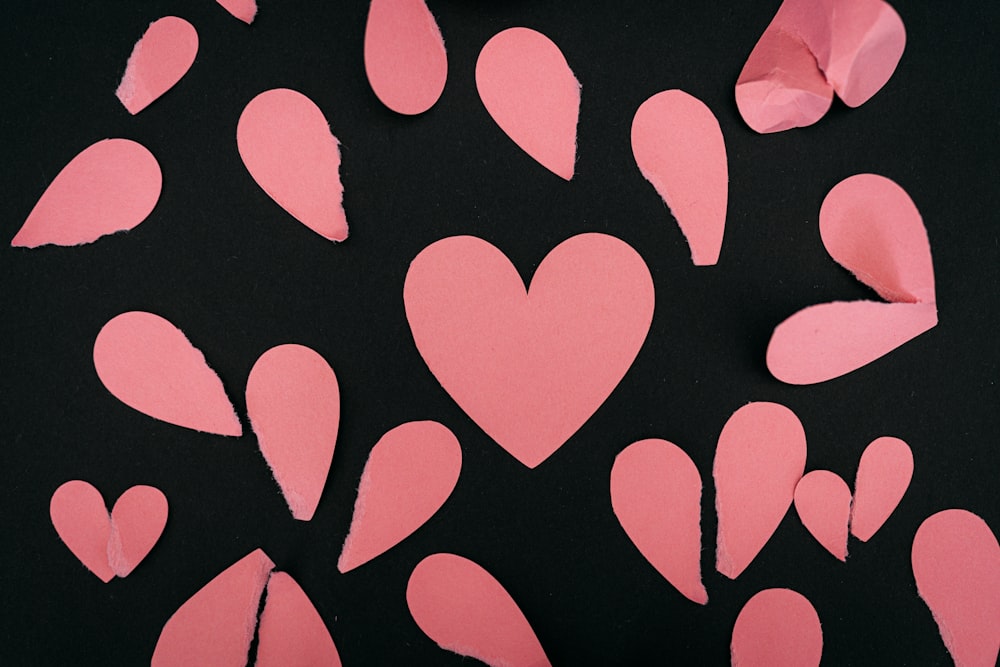 a bunch of pink hearts cut out of paper