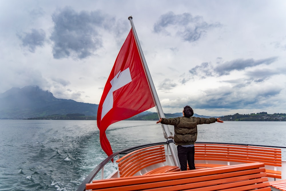 a man standing on a boat holding a flag
