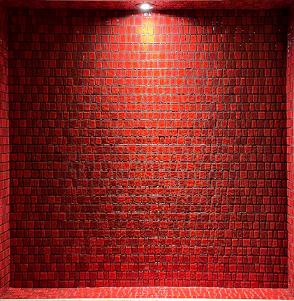 Close-up of sleek black porcelain tiles with glowing red neon edges under soft lighting.