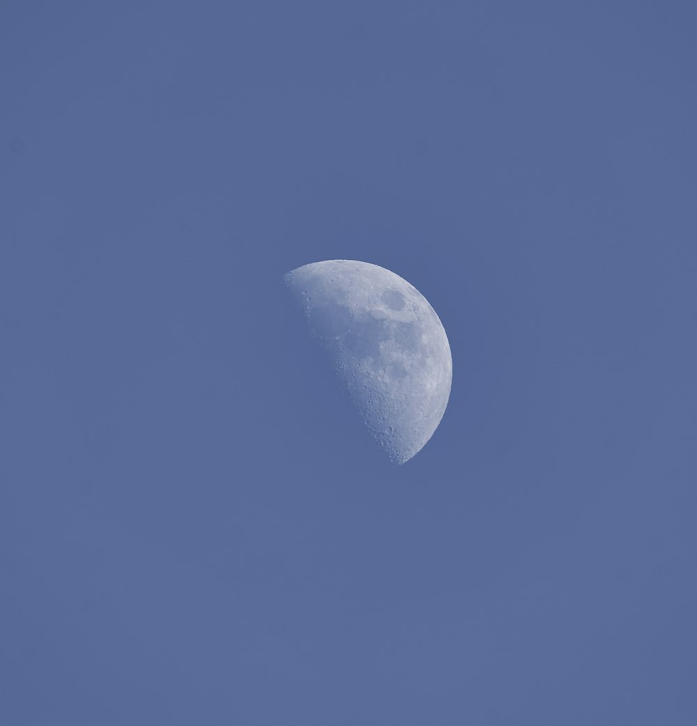 uma meia lua em um céu azul claro