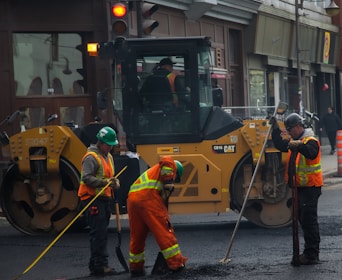Technicians inspecting a road surface with modern safety gear and equipment.