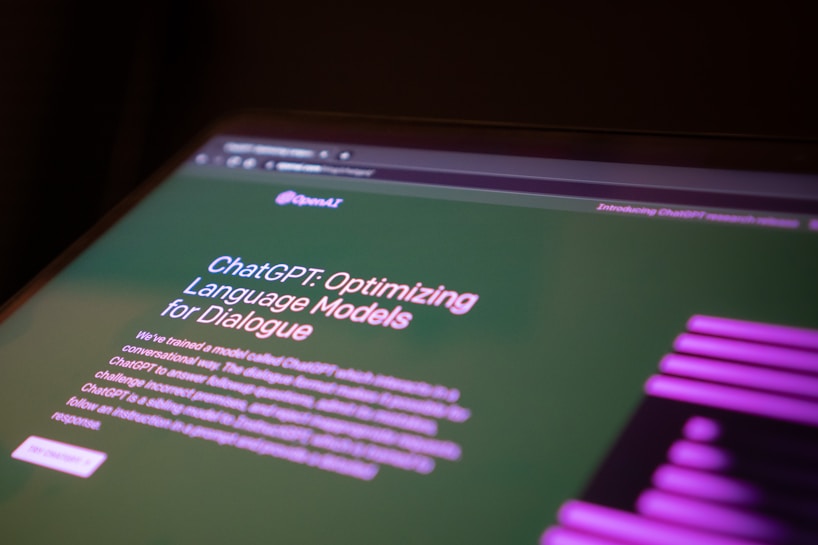 A computer screen displaying a webpage about ChatGPT, focusing on optimizing language models for dialogue. The webpage has text describing the model and includes the OpenAI logo. The background is green with some purple graphical elements on the side.