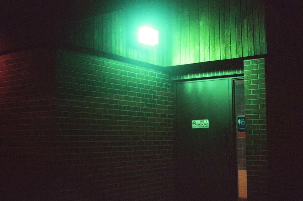 a green light shines on the side of a building