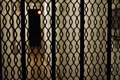 Close-up of a sleek custom metal gate with sharp, clean lines and a brushed steel finish under soft lighting.