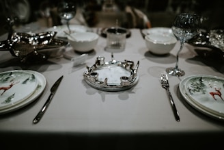 a table set for a formal dinner with silverware