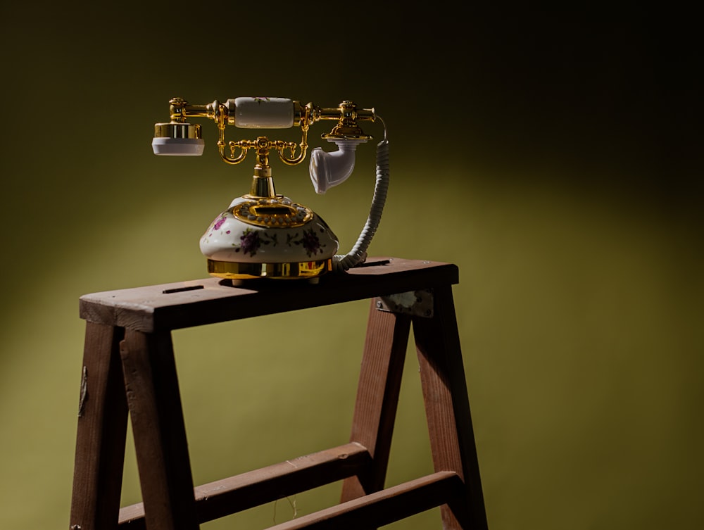 an old fashioned phone sitting on top of a ladder