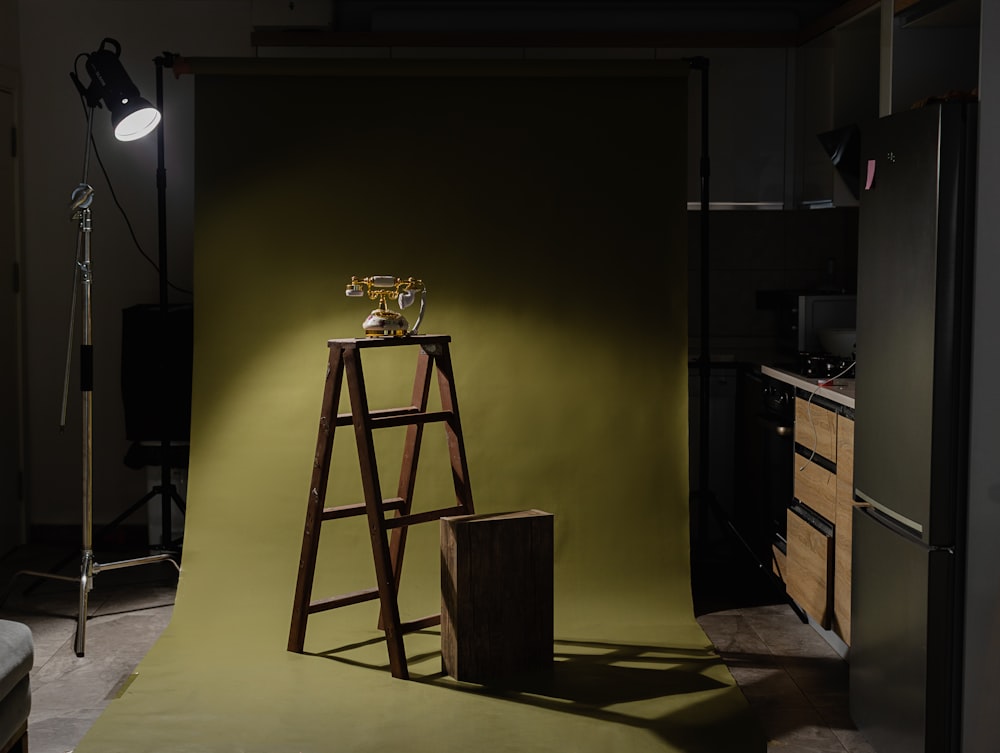 a photo studio with a green backdrop and a ladder