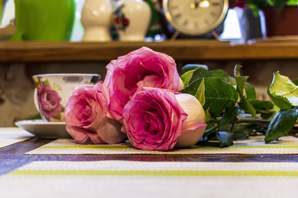 a bunch of pink roses sitting on top of a table