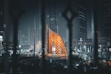 a view of a building through a fence at night