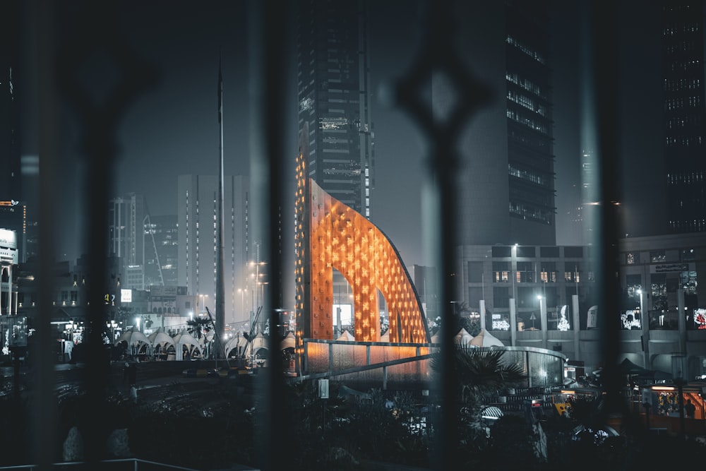 a view of a building through a fence at night