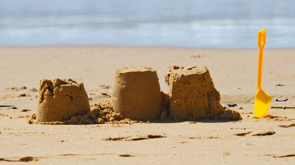 a sand castle on a beach with a shovel