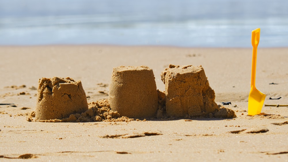 eine Sandburg am Strand mit Schaufel