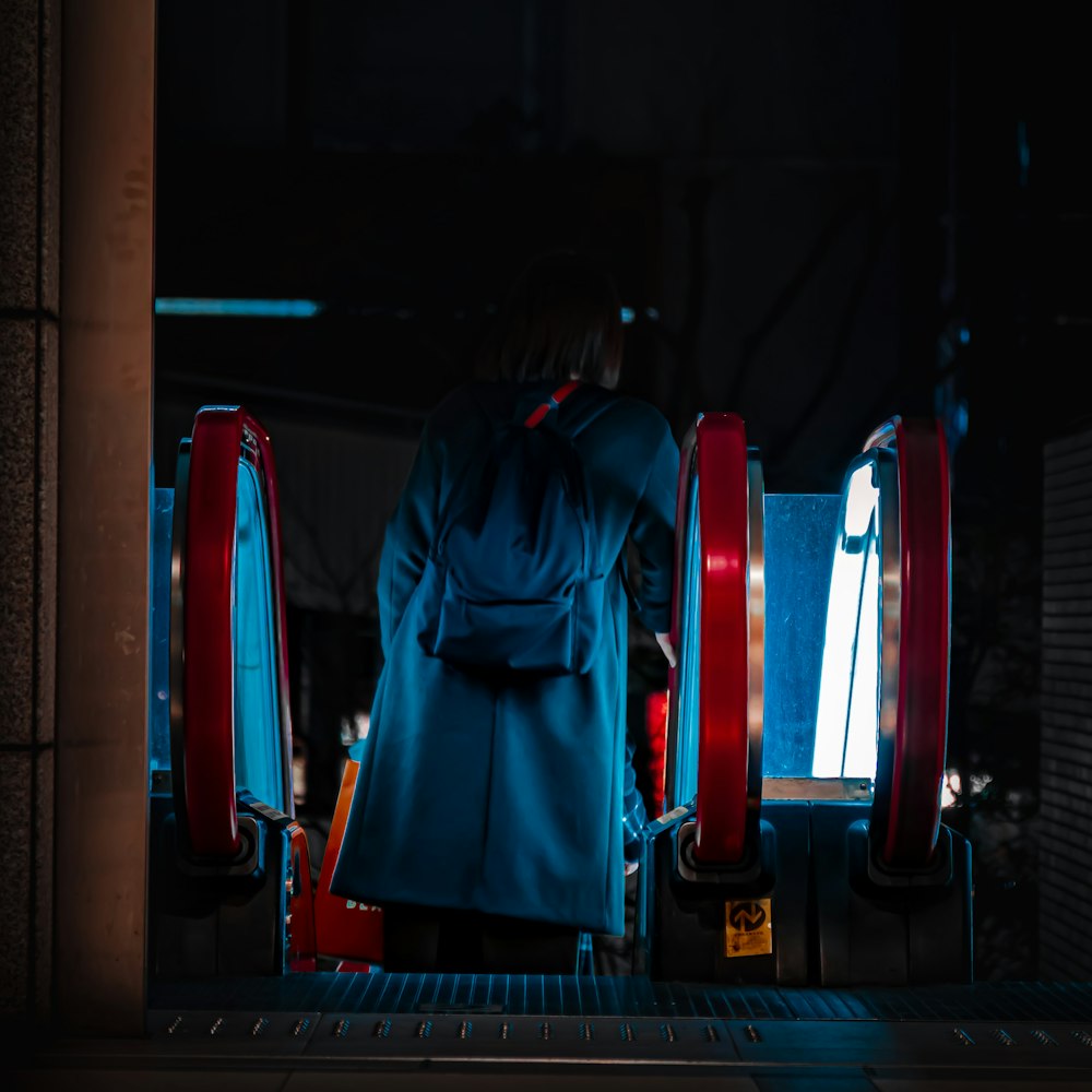 a man in a blue coat standing in front of a machine