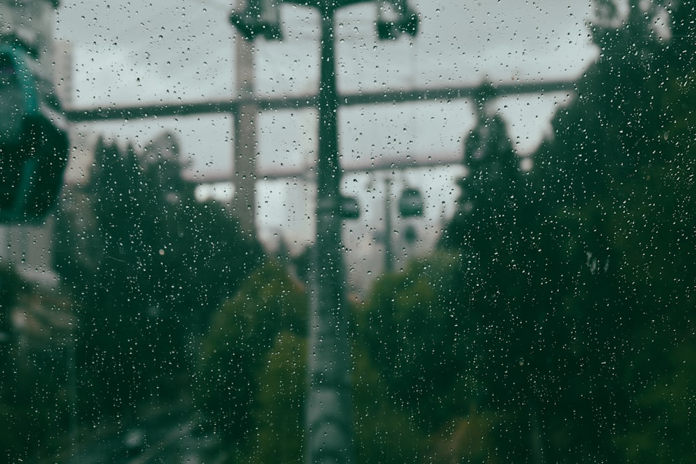 a view of a street sign through a rain covered window