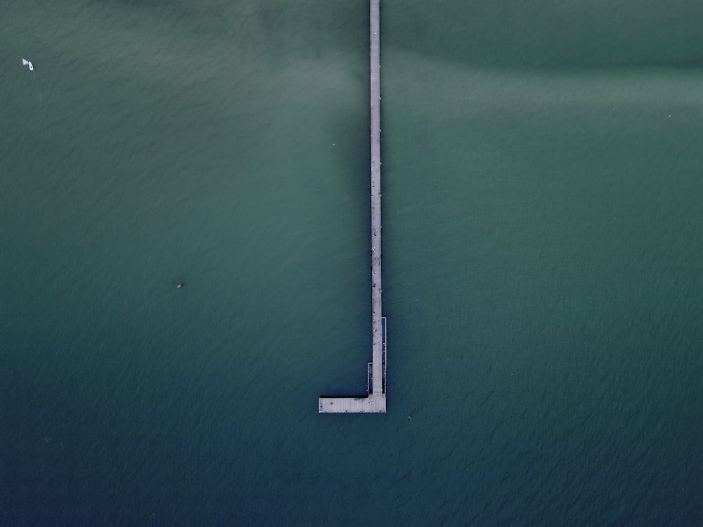 an aerial view of a pier in the middle of a body of water