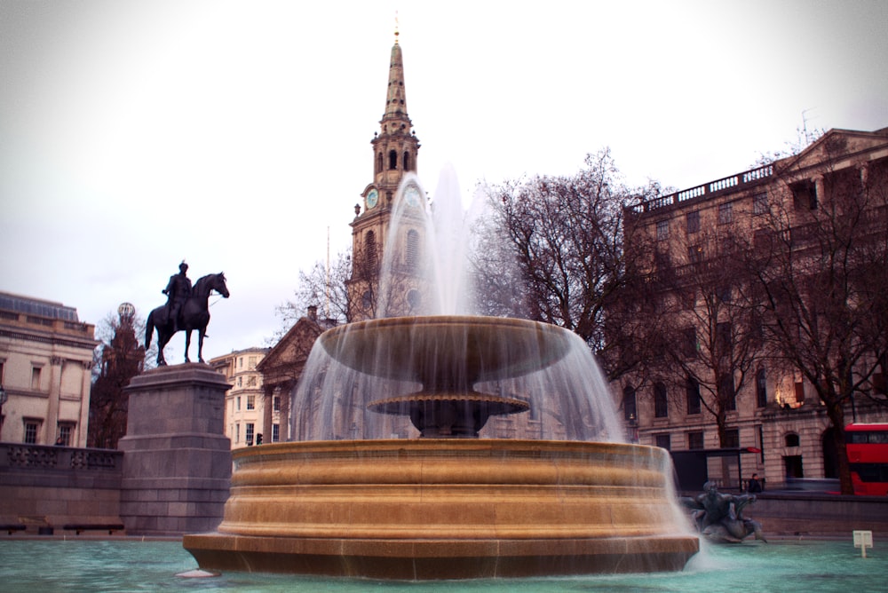 a statue of a man riding a horse next to a fountain