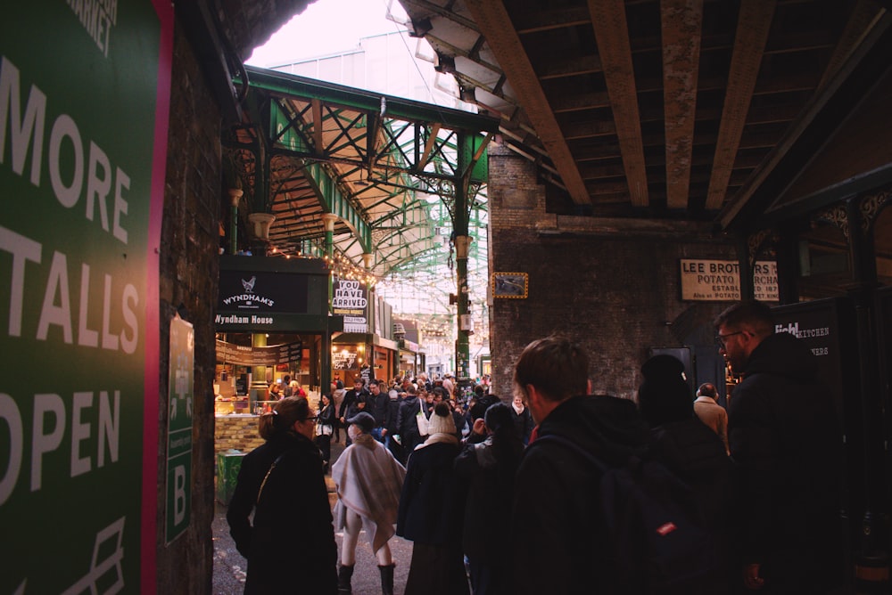 a group of people walking down a street next to a train station