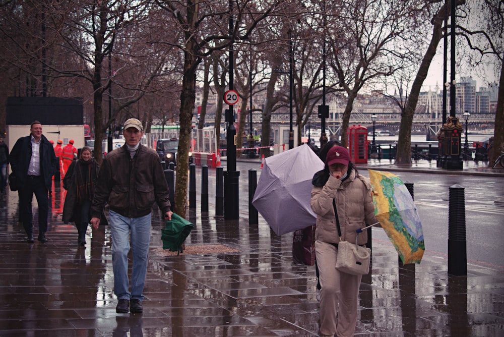 a group of people walking down a street holding umbrellas