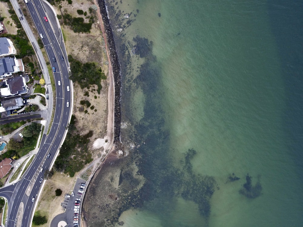 uma vista aérea de uma estrada ao lado de um corpo de água