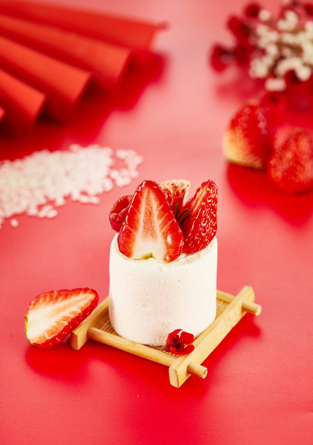 a cake with strawberries on a plate on a red table