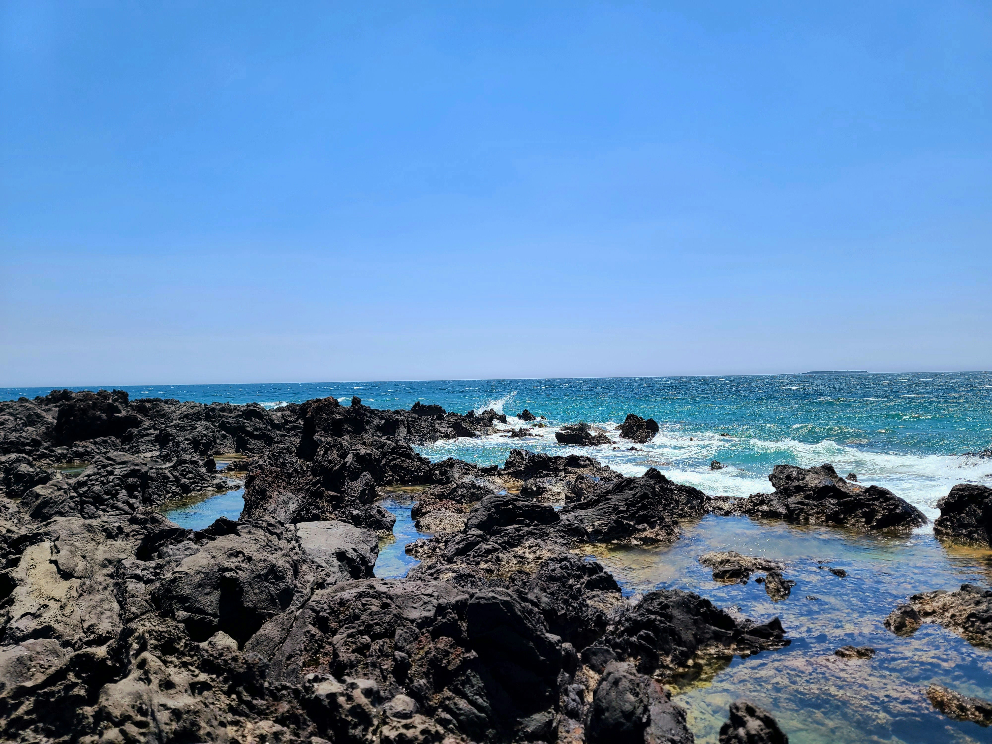 a view of the ocean from a rocky shore, 