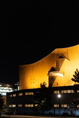 A modern office building illuminated at night with sleek black and gold design.