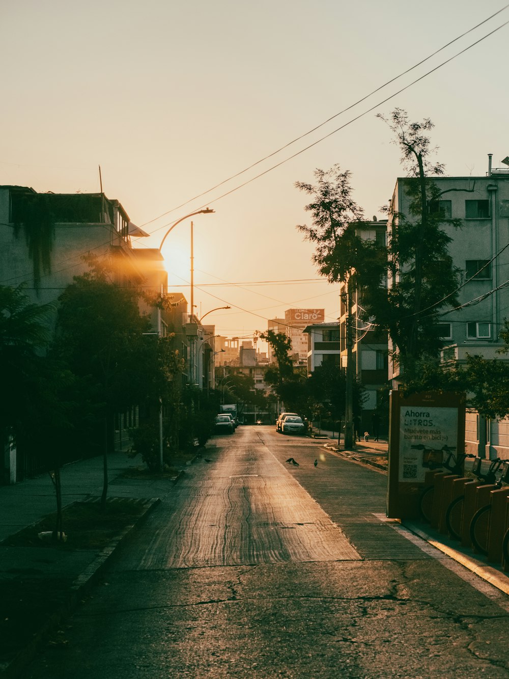 the sun is setting over a city street