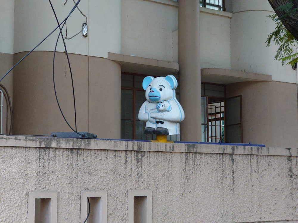 Una estatua de un oso de peluche en el costado de un edificio