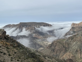 a view of a mountain range with low lying clouds